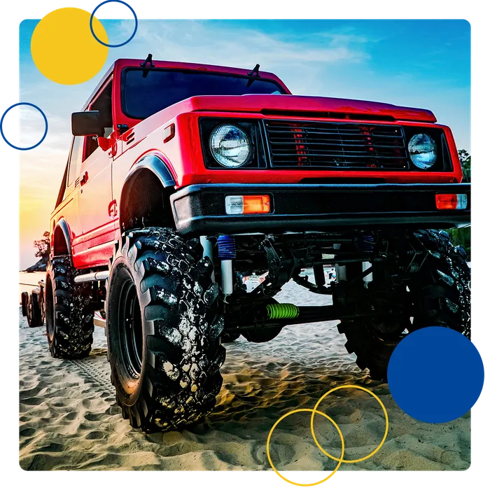 Red off-road truck parked on sand